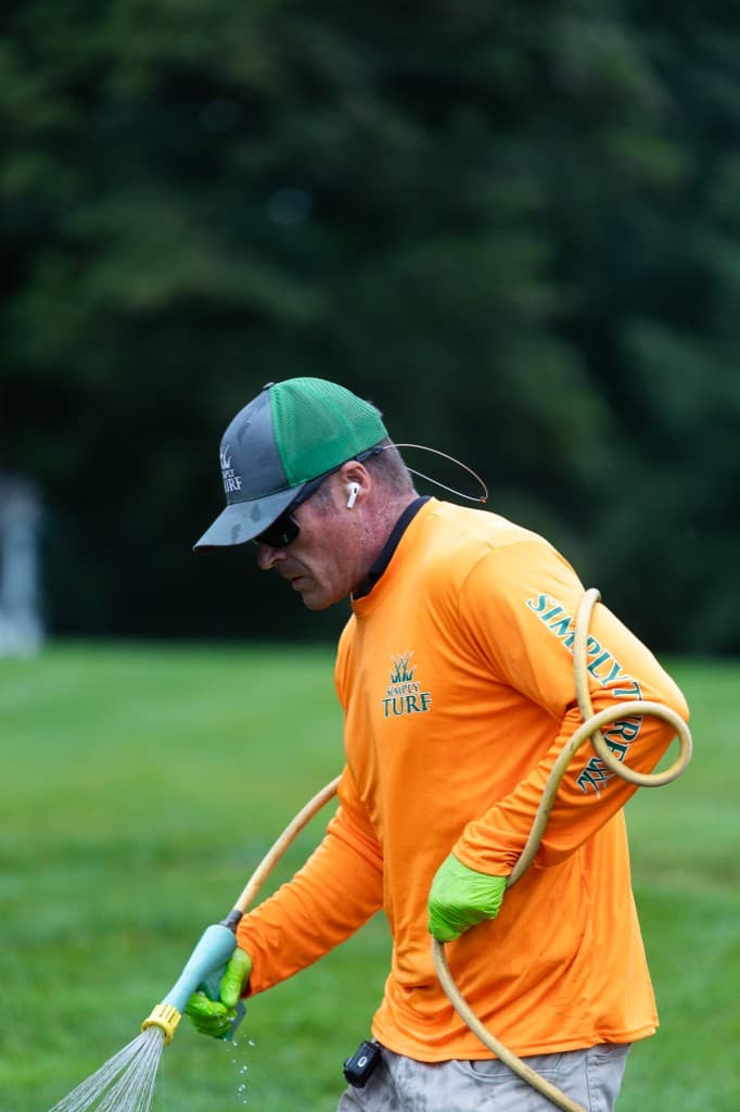Simply Turf technician applying a liquid lawn treatment