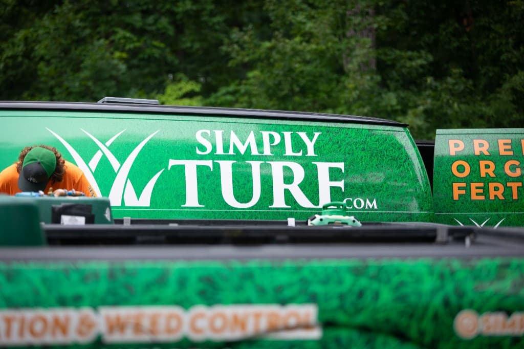Grass-wrapped Simply Turf service trucks