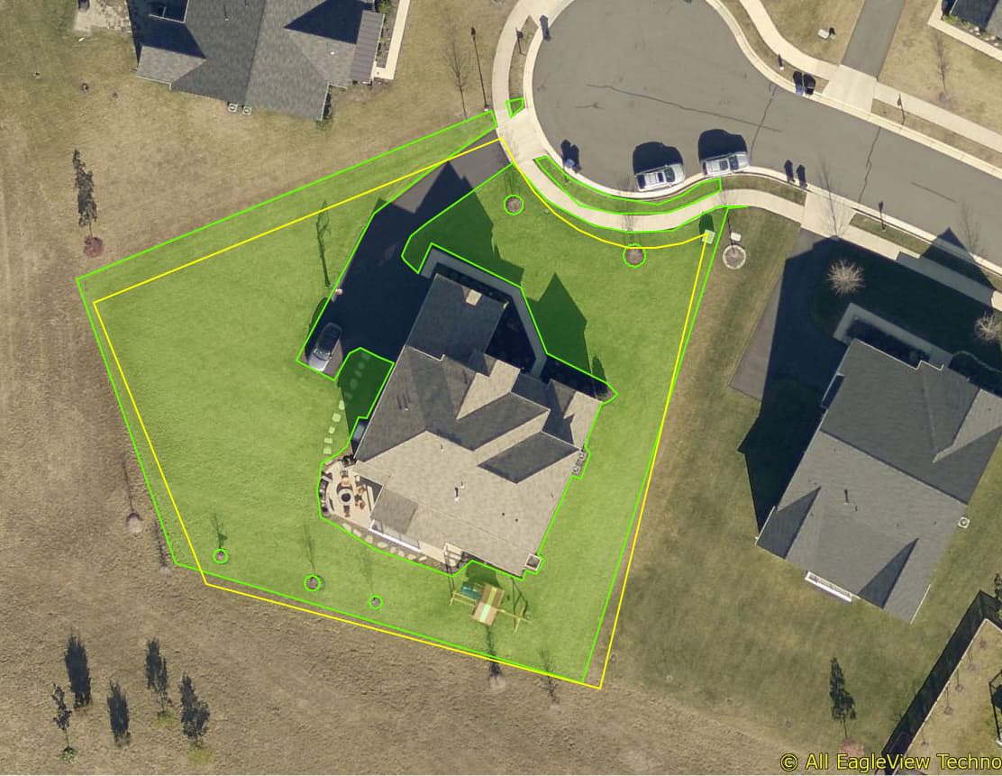 Aerial view of a home with the lawn area highlighted in green for measurement
