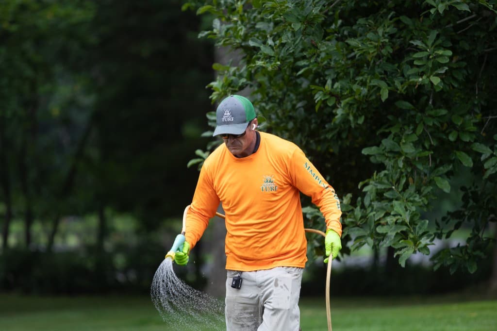 A licensed Simply Turf technician spot-treating weeds in a Northern Virginia lawn